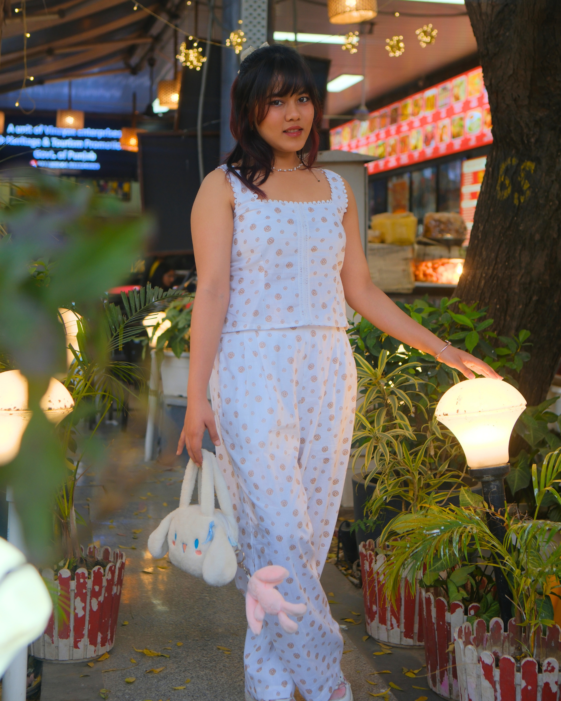 women wearing a white pure cotton everyday wear co ord set by moodora smiling in the streets for dilli haat and enjoying her slow weekend evenings.