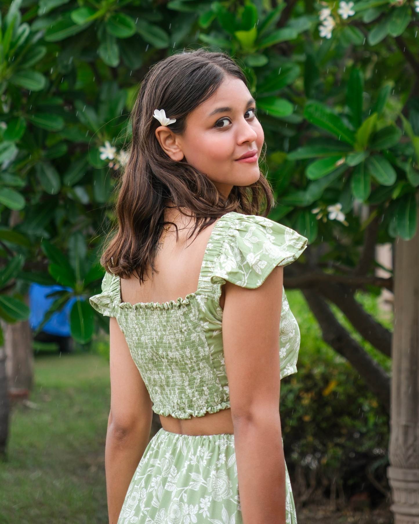 women wearing a green and white leaf printed crop top that has elastics on the sleeves and back for perfect fit.