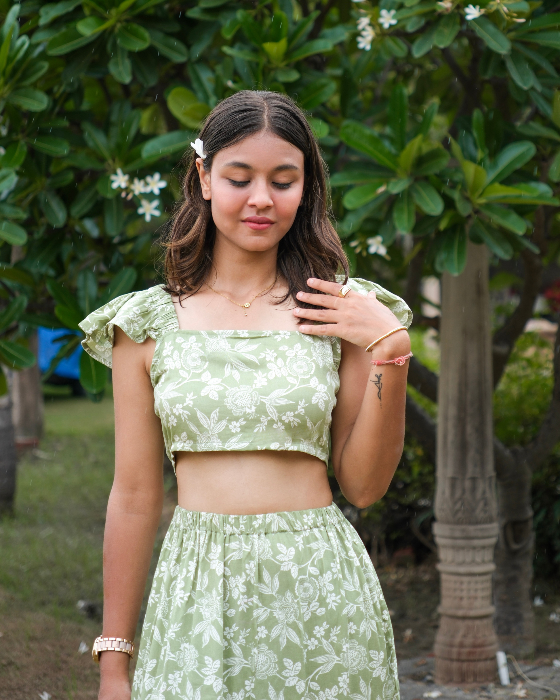 women wearing a cotton rayon floral printed crop top in a park on a summer afternoon.