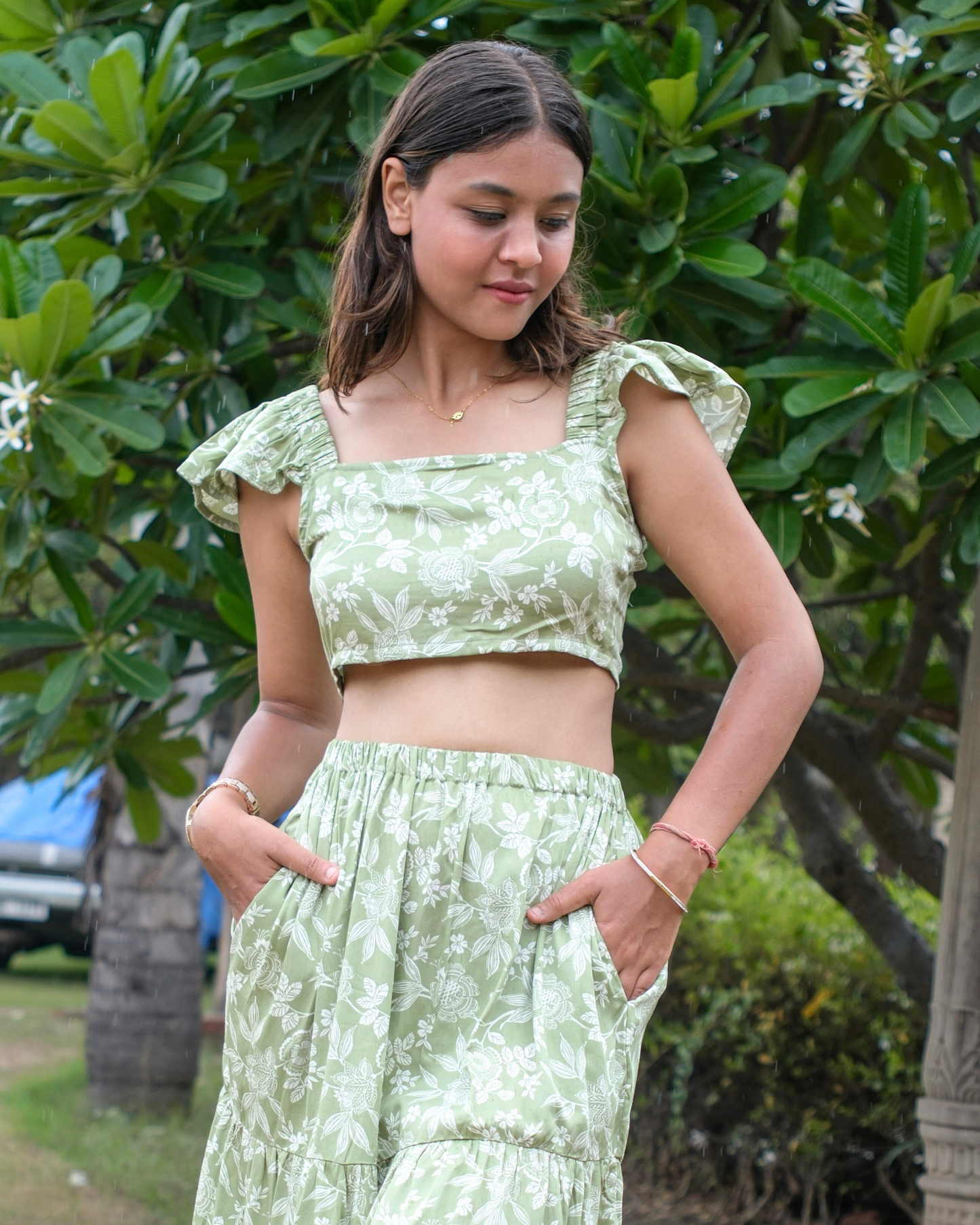women wearing a green and white printed crop top that has a sheen finish on the fabric.