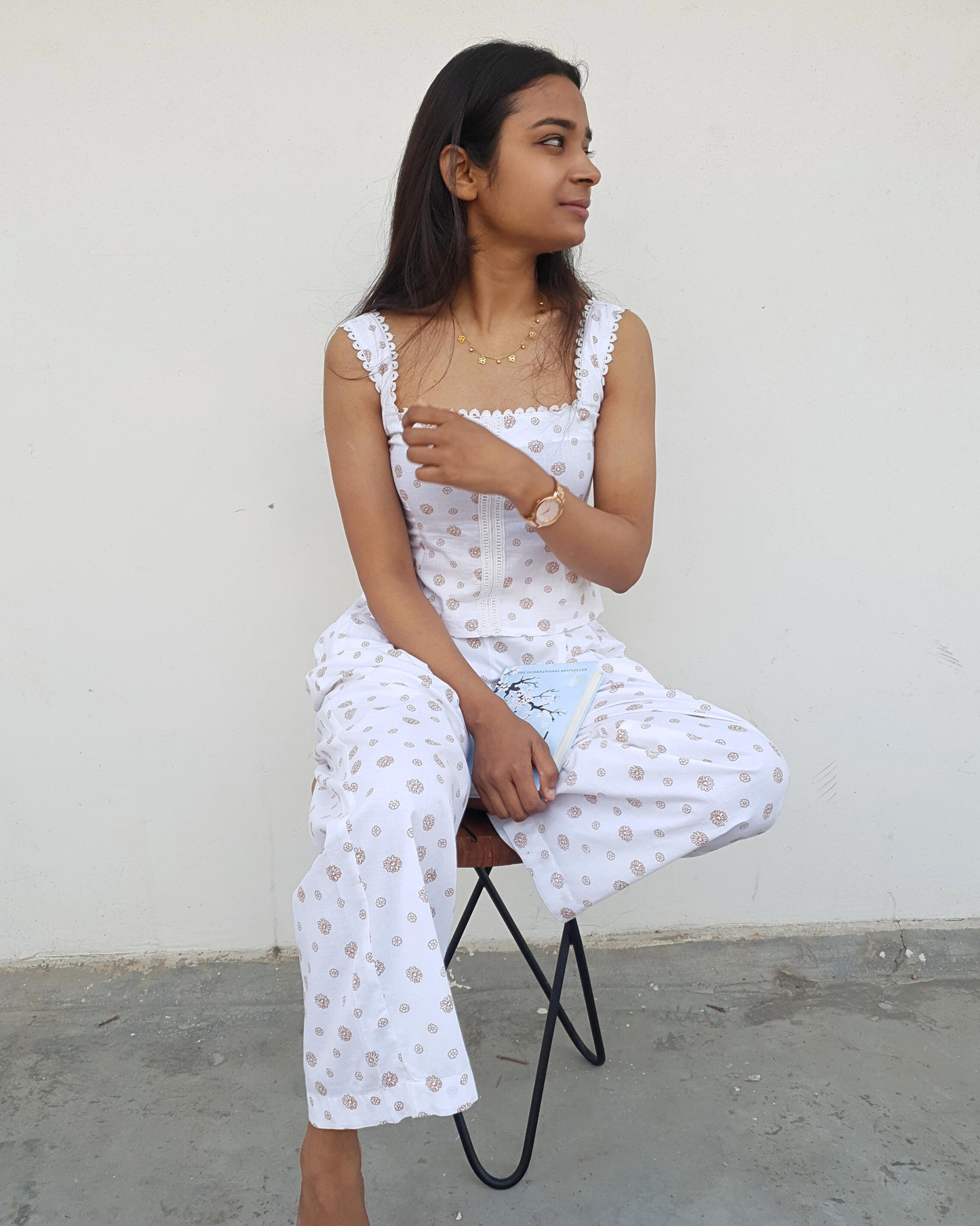 women wearing a pure cotton top and bottom set which is perfect for summers and is sitting on a chair in hot afternoons