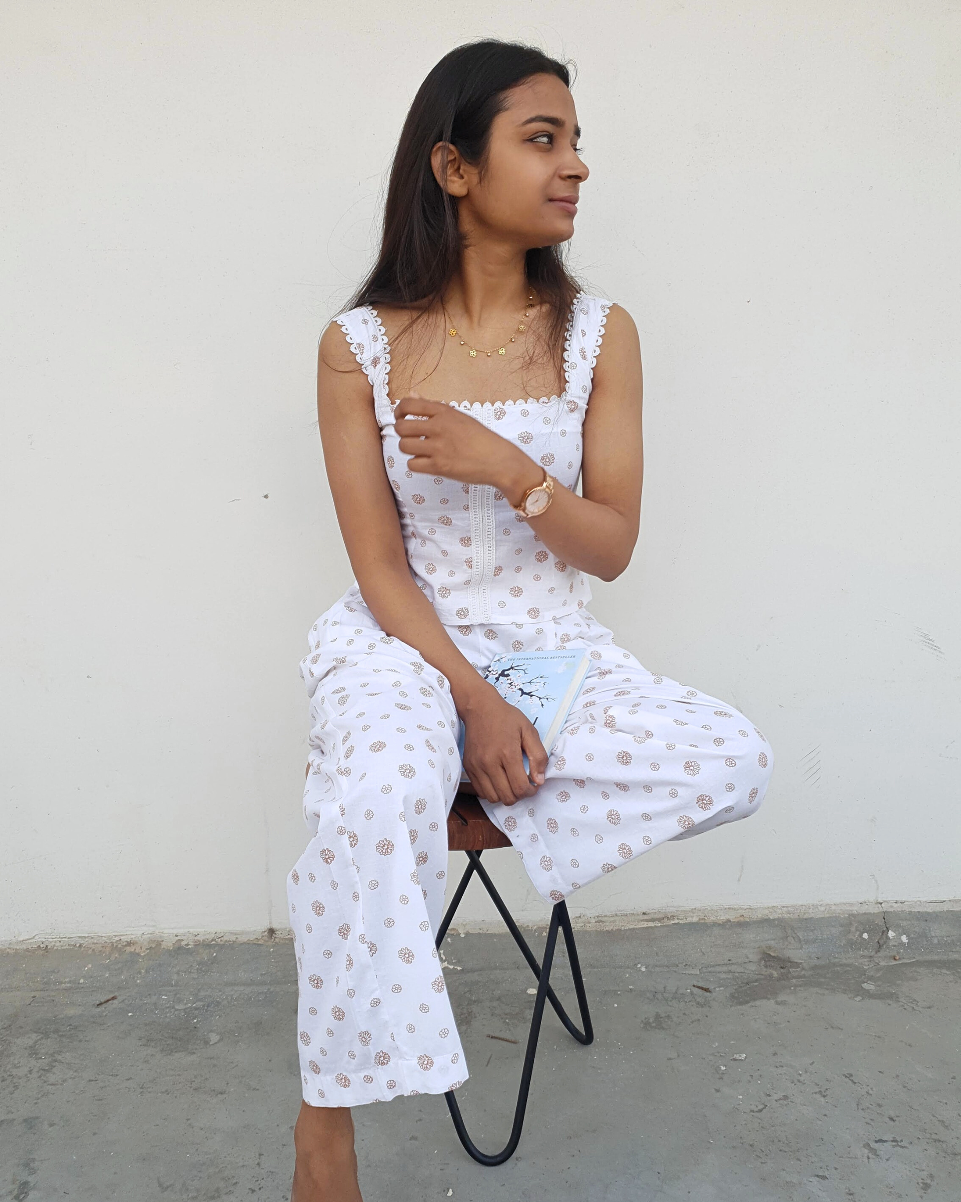 women wearing a pure cotton top and bottom set which is perfect for summers and is sitting on a chair in hot afternoons