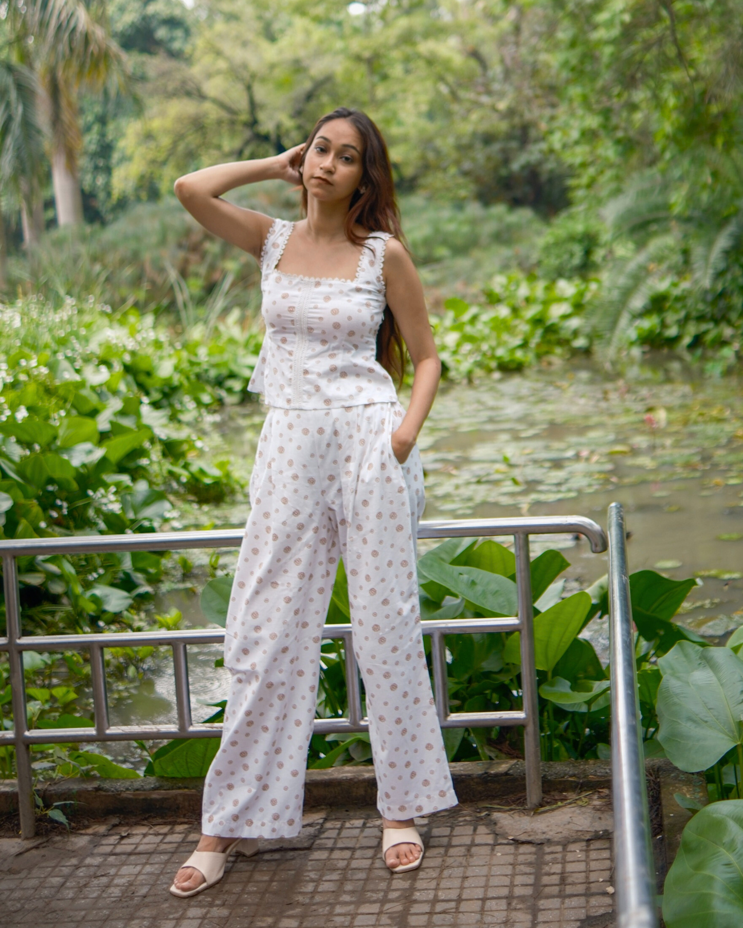 women wearing a pure cotton top and bottom set standing near a water body.