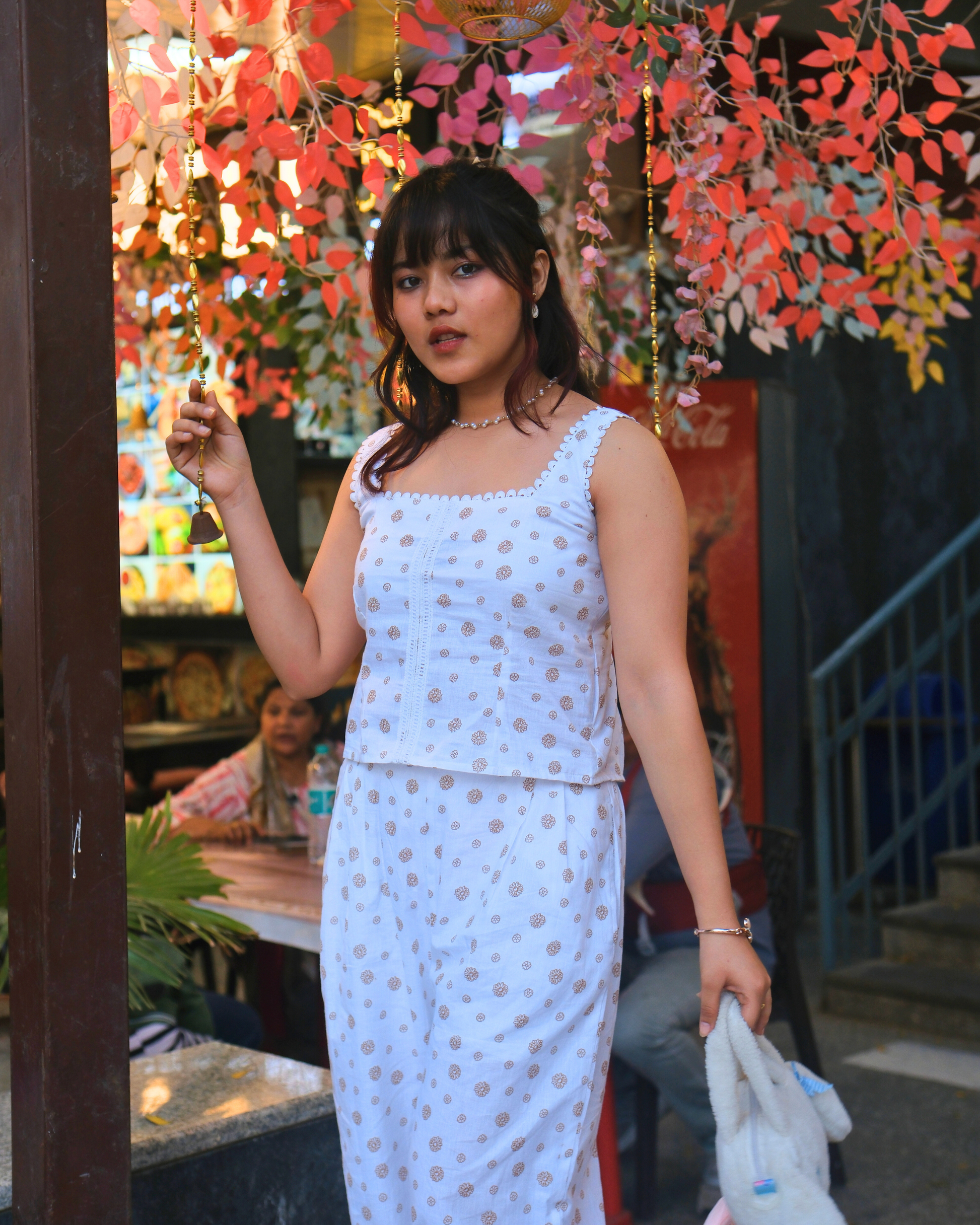 women wearing a white pure cotton everyday wear co ord set by moodora standing in the streets for dilli haat and enjoying her slow weekend